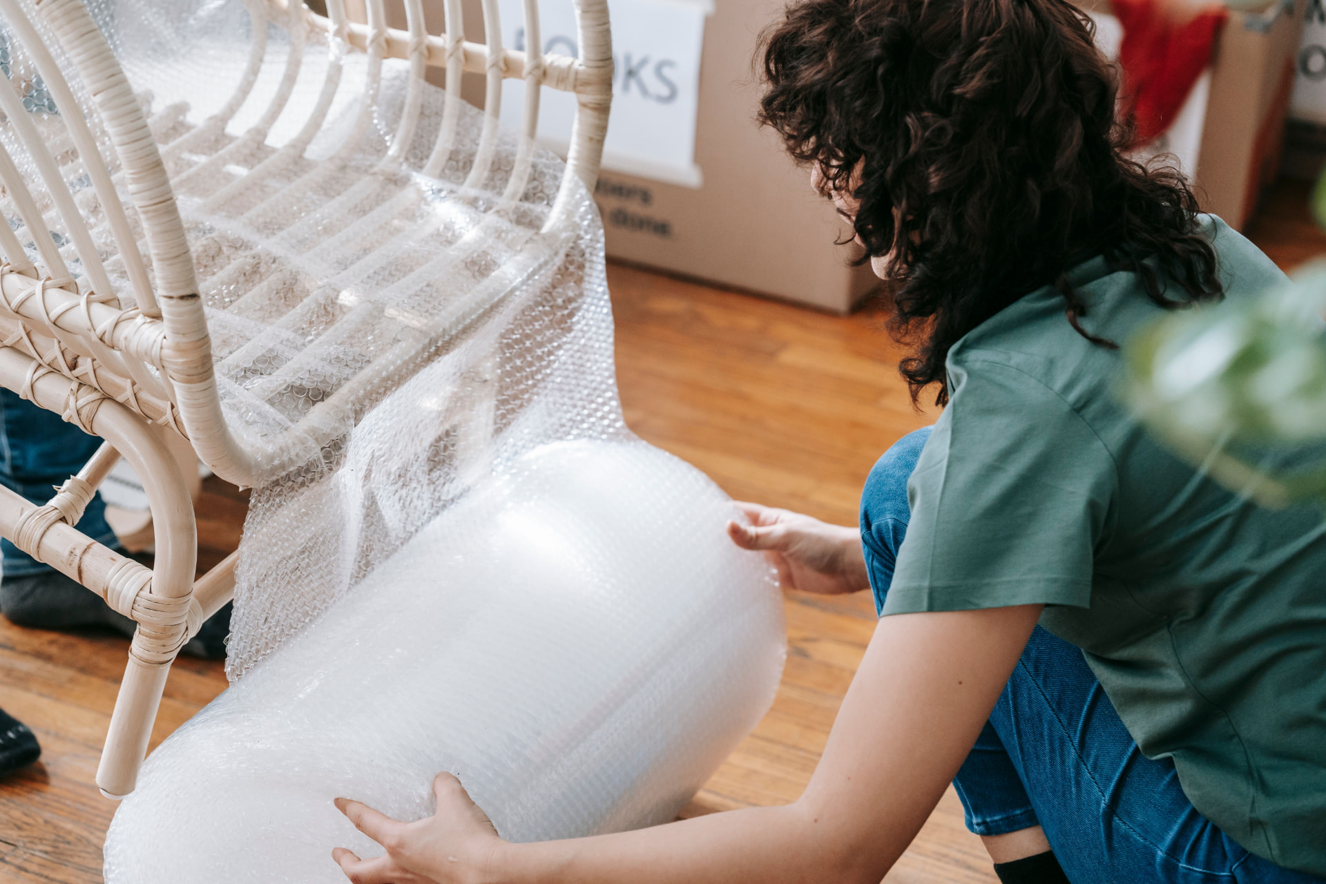 Maker wrapping a chair in protective film before shipping